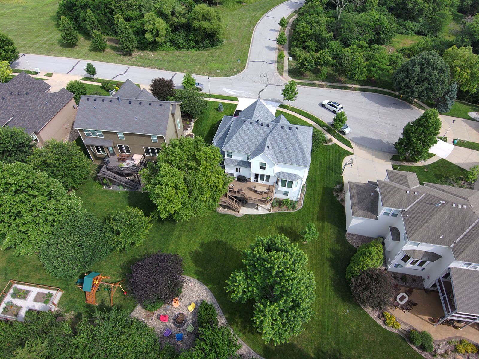 Aerial view of a suburban neighborhood with green lawns and mature trees
